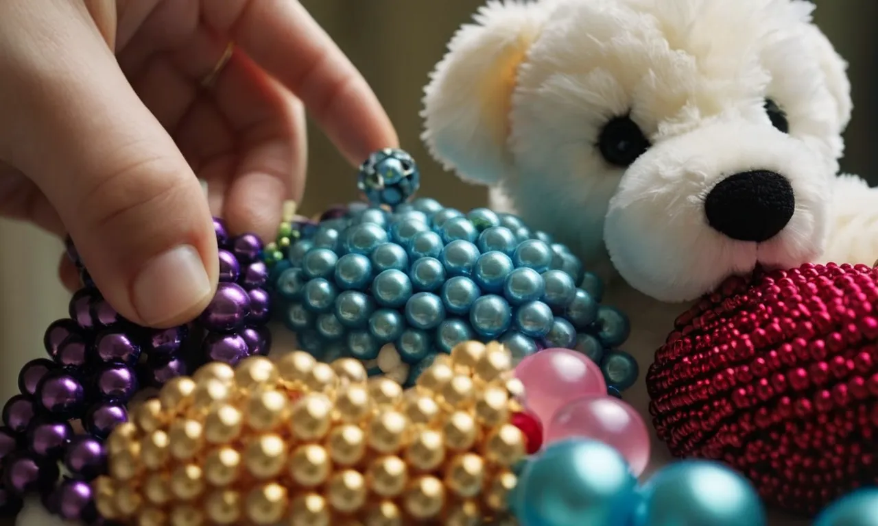 A close-up photo capturing a hand delicately washing a stuffed animal adorned with colorful beads, showcasing the intricate details and care taken in the cleaning process.