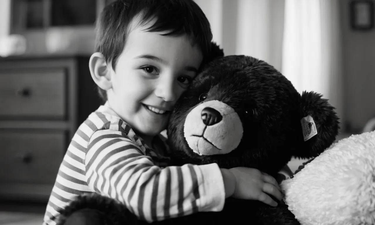 A black and white photo showcasing a young boy, lost in a moment of pure joy, hugging his beloved stuffed bear tightly, defying societal expectations of when he should let go.